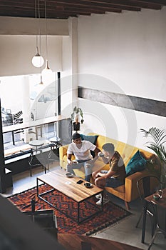 The best stories are shared over coffee. two young men sitting together in a coffee shop.