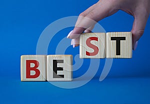 Best symbol. Concept word Best on wooden cubes. Businessman hand. Beautiful blue background. Business and Best concept. Copy space