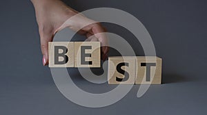 Best symbol. Concept word Best on wooden cubes. Businessman hand. Beautiful grey background. Business and Best concept. Copy space