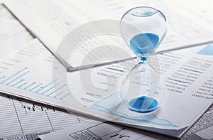 Best time for investment. Hourglass, financial charts and calculator