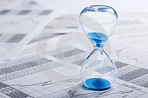 Best time for investment. Hourglass, financial charts and calculator