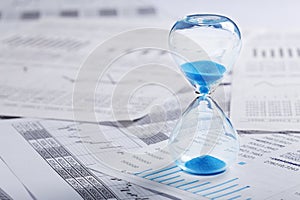 Best time for investment. Hourglass, financial charts and calculator