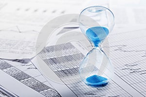 Best time for investment. Hourglass, financial charts and calculator