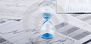 Best time for investment. Hourglass, financial charts and calculator