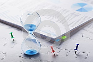 Best time for investment. Hourglass, financial charts, calculator and calendar with pins