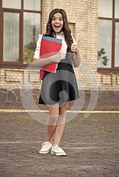 Best time is school time. Happy child give thumbs up outdoors. Back to school. Formal education. Fashion schoolwear