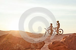 The best way to explore nature. Full length shot of two young male athletes mountain biking in the wilderness.