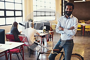 The best way to move around the office. a handsome man on a bicycle in a modern office.