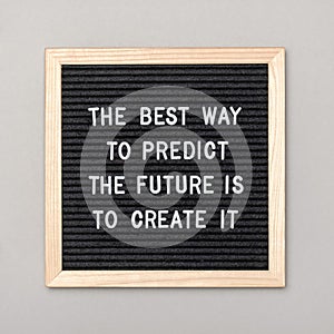 The best way to predict the future is to create it. Motivational quote on letter board, gray background. Concept inspirational