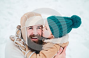 Best winter game for happy family. Happy family son hugs his dad on winter holiday. Daddy and boy smiling and hugging