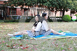 Bestie Happy cute lovely beautiful young girl high school college student enjoy free time read a book at school on grass lawn