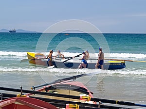 Bethells Beach club women crew boat being put into water at surf-lifesaving competitions