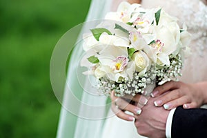 Betrothed pair holding a delicate bouquet