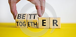 Better together symbol. Businessman turns cubes and changes the word together to better. Beautiful yellow table, white background