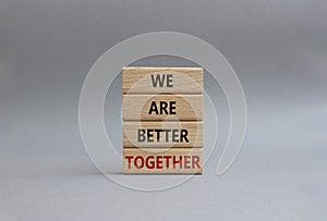 We are better together symbol. Wooden blocks with words We are better together. Beautiful grey background. We are better together