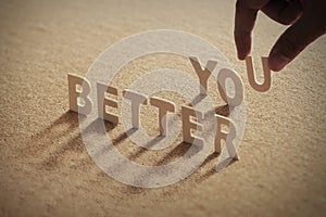 â€œBETTER YOUâ€ wood word on compressed or corkboard