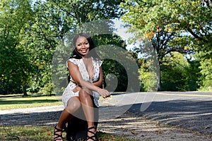 Beuatiful African American woman sitting next to road