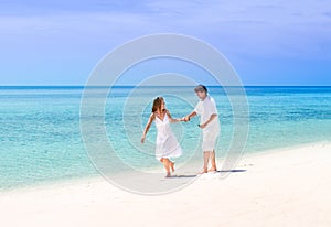 Beuatiful couple running on a tropical beach