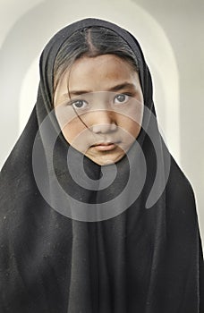 Beutiful girl with scarf and long black shawl inside a suni mosque