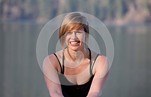 Beutiful happy girl posing by a lake