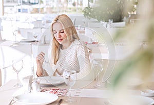 Beutiful young woman in cafe in sunny day photo