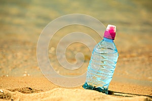 Bevarage. bottle of water drink on a sandy beach.