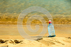 Bevarage. bottle of water drink on a sandy beach.