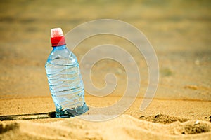 Bevarage. bottle of water drink on a sandy beach.