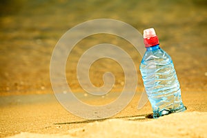 Bevarage. bottle of water drink on a sandy beach.