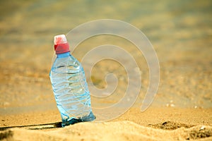 Bevarage. bottle of water drink on a sandy beach.