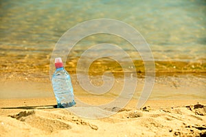 Bevarage. bottle of water drink on a sandy beach.