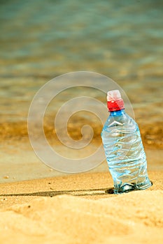 Bevarage. bottle of water drink on a sandy beach.