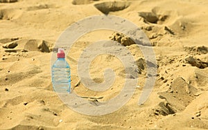 Bevarage. bottle of water drink on a sandy beach.