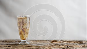 Beverage background of a glass of cold milk coffee on wooden table with white background