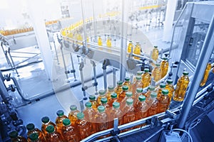 Beverage factory, Conveyor belt with juice in bottles, Industrial Interior in blue color, food and drink production line