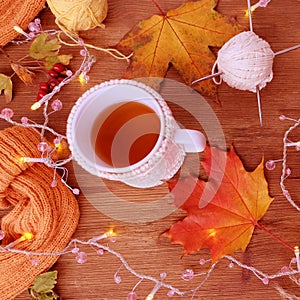 Beverage, hot drink in a mug, leaves, foliage, garland, candles, top view of wooden table, good weather concept, outdoor tea party