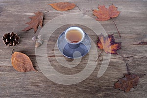 beverage, hot drink in a mug, leaves, foliage, top view of wooden table, good weather concept, outdoor tea party, cozy autumn mood