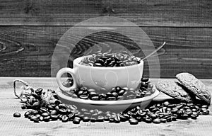 Beverage for inspiration and energy charge. Cup full coffee brown roasted bean blue wooden background. Caffeine concept