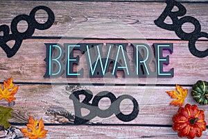 Beware boo Halloween background on wood backdrop with pumpkins