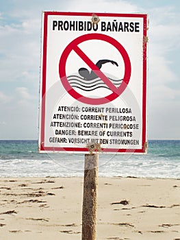 Beware of currents. Signalpost on the beach
