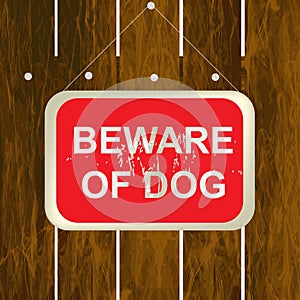 Beware of a dog sign on a wooden fence