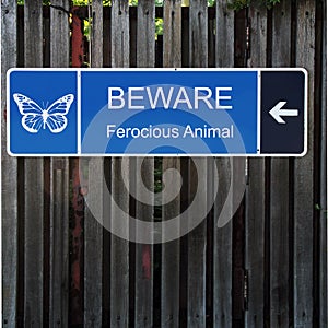 Beware Horizontal Blue Sign on Old Wood Fence