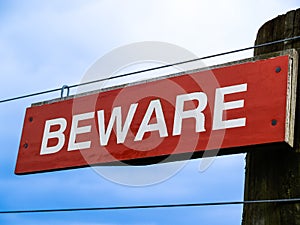 Beware  sign in white lettering on red background