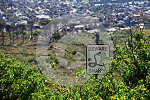 Beware snakes sign post in the bushes of Capetown, South Africa