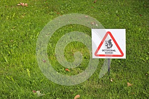 Beware of squirrel sign on grass close up