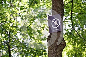 Beware of ticks. Warning sign in the spring city park.