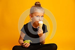 Bewildered little girl in leotard and dance shoes choosing between healthy and unhealthy food