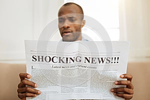 Bewildered man reading shocking news