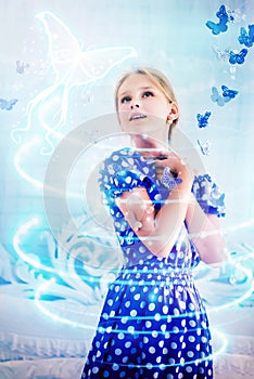 Bewitched little girl in a blue polka-dot dress photo