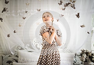 Bewitched little girl in a blue polka-dot dress photo
